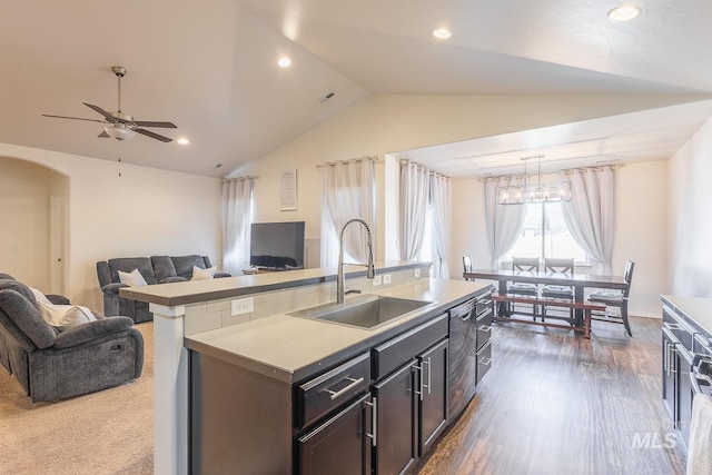 kitchen featuring lofted ceiling, sink, dark hardwood / wood-style floors, a center island with sink, and ceiling fan with notable chandelier