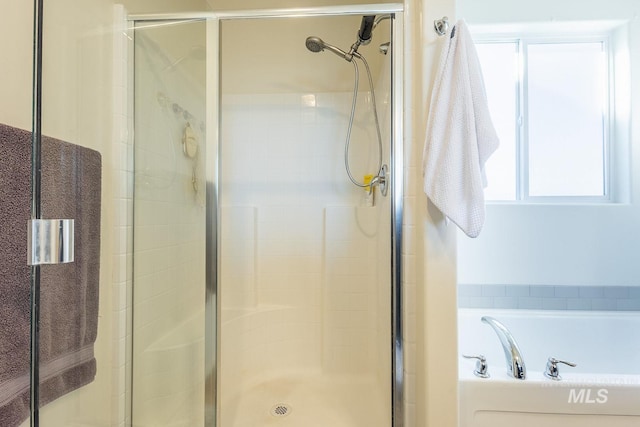 bathroom featuring separate shower and tub