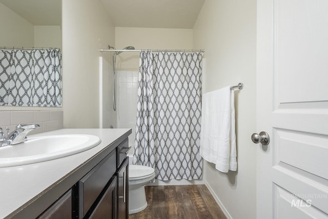 bathroom with toilet, a shower with curtain, wood-type flooring, vanity, and decorative backsplash