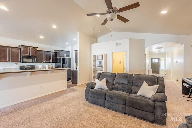 carpeted living room featuring sink, vaulted ceiling, and ceiling fan