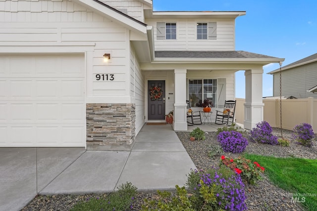 doorway to property featuring a garage and covered porch