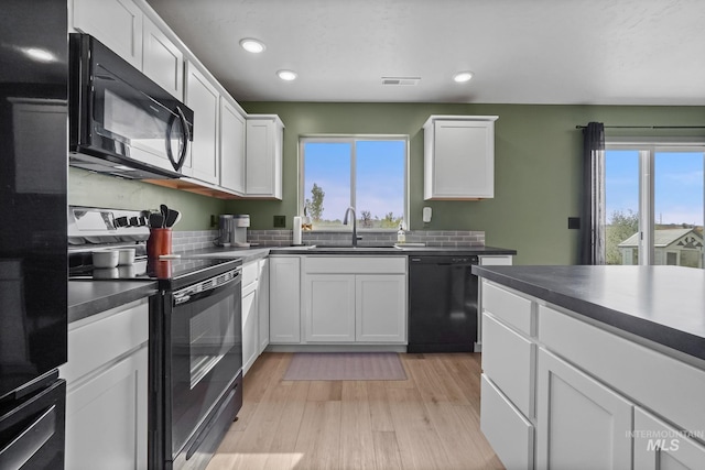 kitchen with sink, plenty of natural light, black appliances, and white cabinets