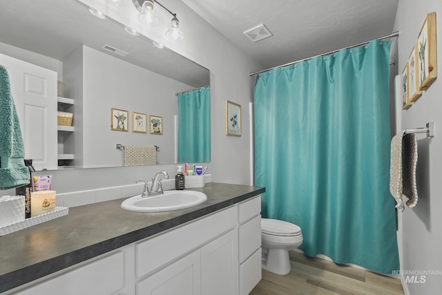 bathroom featuring vanity, curtained shower, wood-type flooring, and toilet