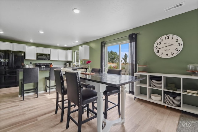 dining space with sink and light hardwood / wood-style floors