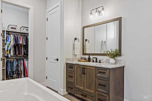 bathroom with vanity and a washtub