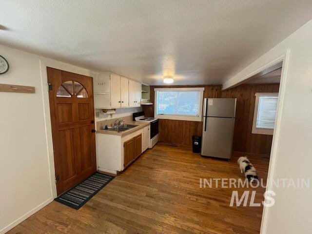 kitchen featuring white cabinets, refrigerator, white electric stove, sink, and light wood-type flooring