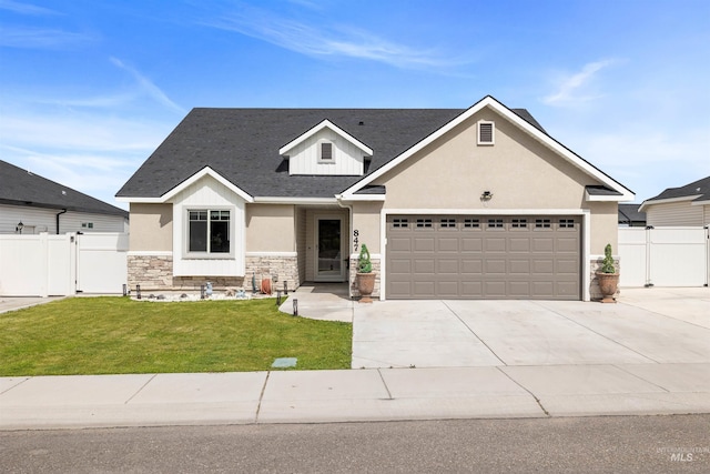 847 Bridget St, Twin Falls, ID 83301 - view of front of house featuring stone siding, concrete driveway, a gate, stucco siding, and a garage