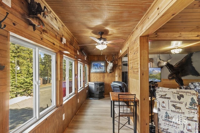 sunroom with wooden walls, wood ceiling, and wood finished floors