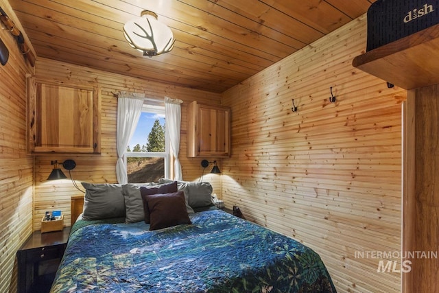 bedroom featuring wooden ceiling and wood walls