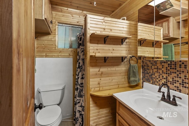 full bath with vanity, backsplash, toilet, and wood walls