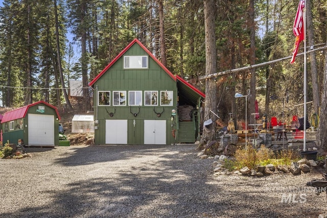 exterior space with driveway, an outbuilding, and a garage