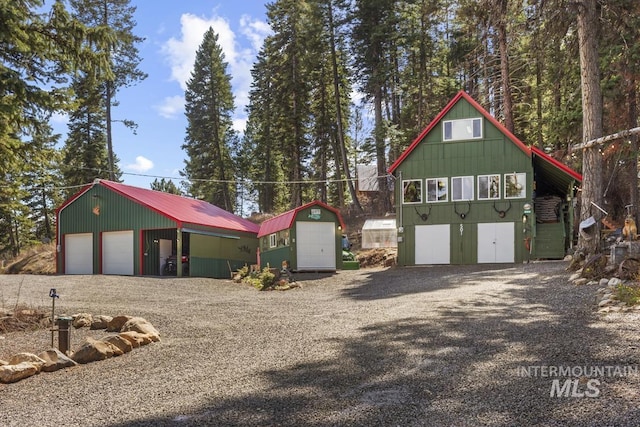 view of front facade with an outdoor structure, a garage, and driveway