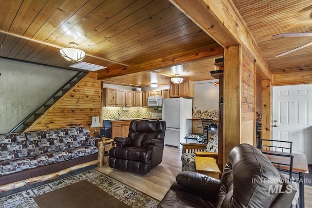 living room featuring wooden walls, a ceiling fan, wooden ceiling, and light wood-style flooring