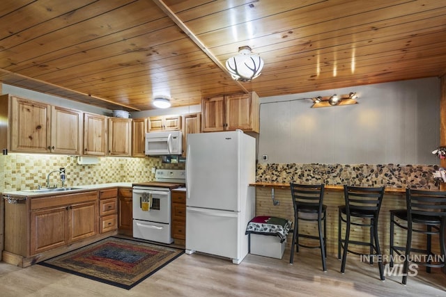 kitchen with white appliances, wooden ceiling, tasteful backsplash, a sink, and light wood-style flooring
