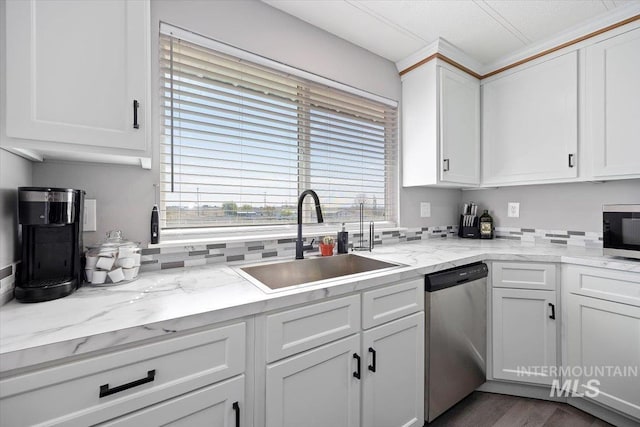 kitchen featuring a sink, white cabinets, light stone countertops, and stainless steel appliances