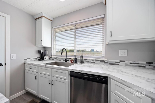 kitchen featuring dark wood-style flooring, light stone countertops, white cabinets, a sink, and dishwasher