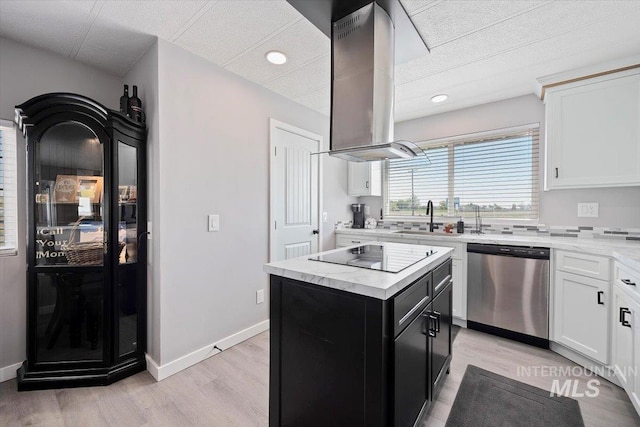 kitchen featuring dishwasher, a sink, black electric stovetop, dark cabinetry, and light wood-style flooring