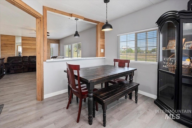 dining room with wooden walls, baseboards, and wood finished floors