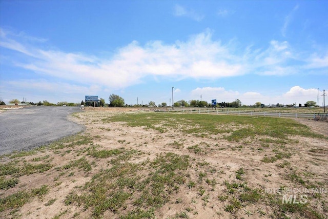 view of yard featuring fence and a rural view
