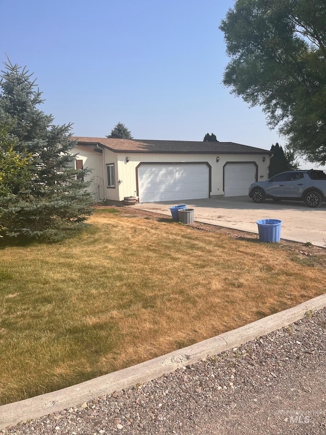 view of front of home with a front yard and a garage