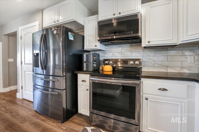 4076 N 3446 E, Kimberly, ID 83341 - kitchen featuring appliances with stainless steel finishes, dark countertops, dark wood finished floors, white cabinets, and tasteful backsplash