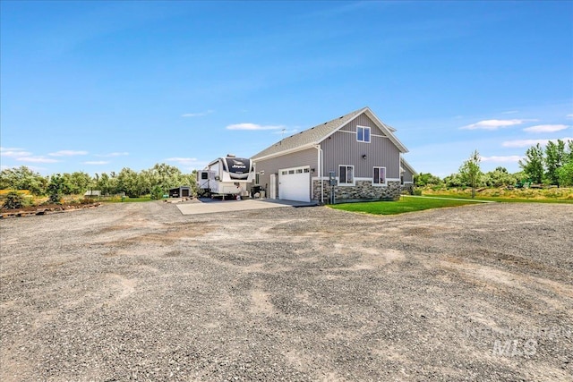 4076 N 3446 E, Kimberly, ID 83341 - view of home's exterior featuring a garage, driveway, and stone siding