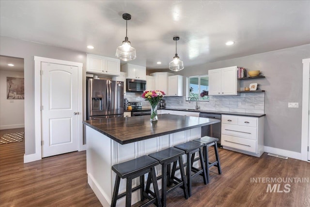 4076 N 3446 E, Kimberly, ID 83341 - kitchen with appliances with stainless steel finishes, white cabinets, backsplash, a kitchen breakfast bar, and recessed lighting