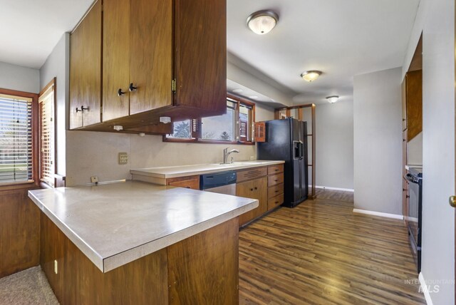 620 Monte Vista Dr, Twin Falls, ID 83301 - kitchen featuring dark wood-style flooring, a sink, a peninsula, brown cabinets, and black appliances