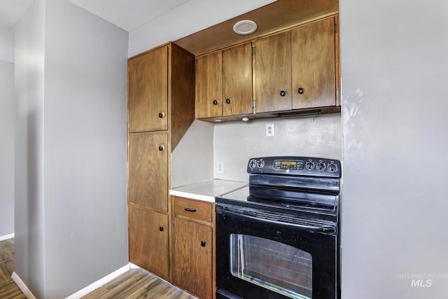 620 Monte Vista Dr, Twin Falls, ID 83301 - kitchen with black electric range oven, light wood finished floors, brown cabinets, and baseboards