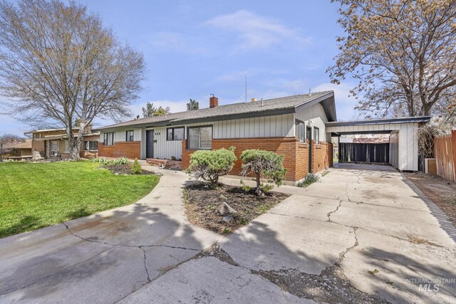 620 Monte Vista Dr, Twin Falls, ID 83301 - ranch-style house with a chimney, fence, concrete driveway, brick siding, and a front lawn