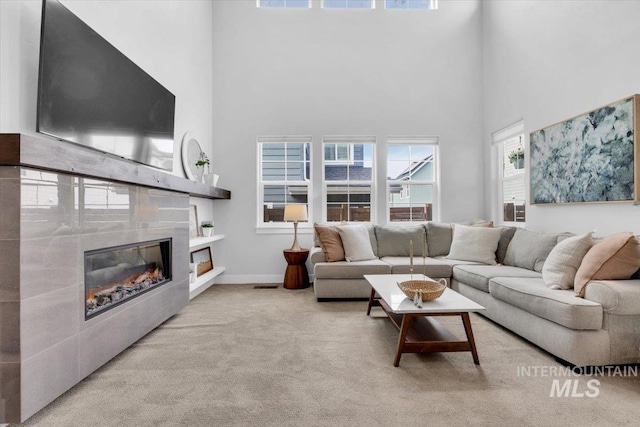 2959 S Shady Ln, Boise, ID 83716 - living area featuring a towering ceiling, a tile fireplace, light colored carpet, and baseboards