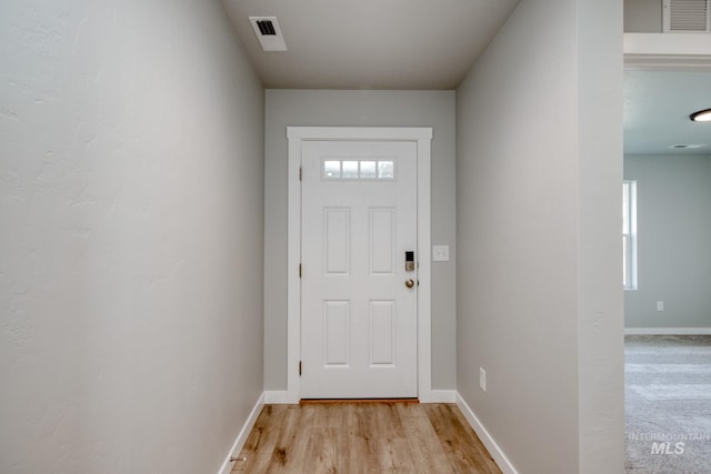 doorway to outside featuring visible vents, light wood finished floors, and baseboards