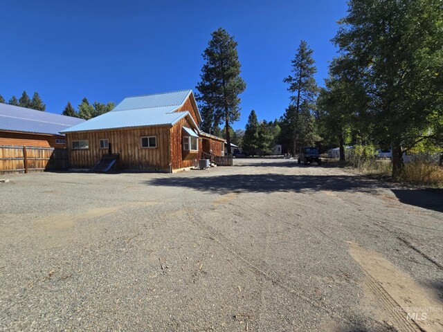379 S Mill St, Sumpter, OR 97877 - rear view of property featuring board and batten siding, driveway, central air condition unit, and metal roof