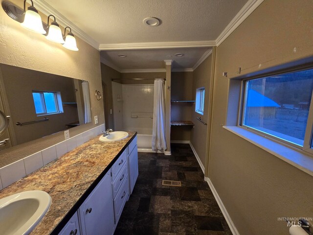 bathroom with shower / tub combo with curtain, ornamental molding, vanity, and a textured ceiling