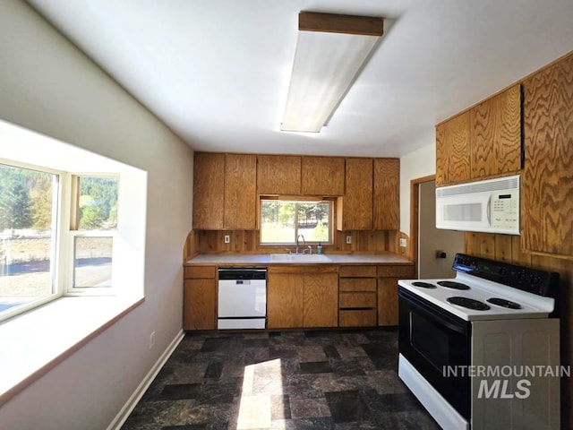 379 S Mill St, Sumpter, OR 97877 - kitchen with white appliances, brown cabinets, a sink, and stone finish floors
