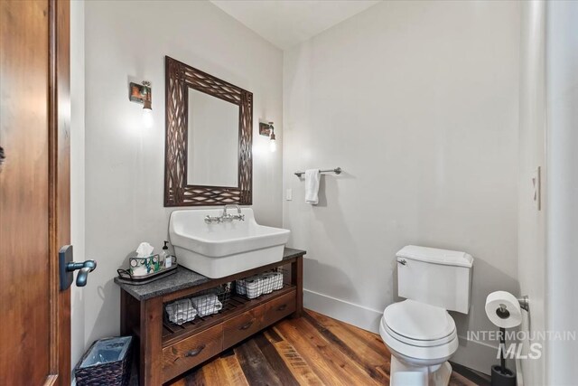 212 Ferguson Way, Mccall, ID 83638 - half bath with wood finished floors, toilet, baseboards, and vanity