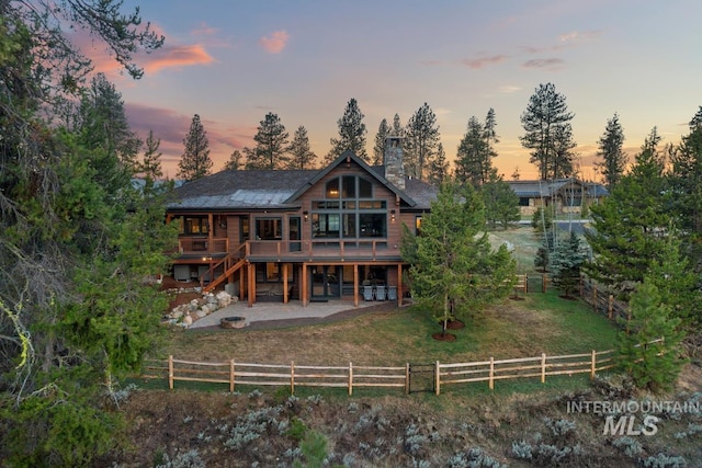 212 Ferguson Way, Mccall, ID 83638 - back of house at dusk with a patio area, a chimney, a deck, and stairway