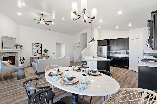 19126 Red Eagle Way, Caldwell, ID 83605 - dining area with vaulted ceiling, light wood-style floors, a ceiling fan, stairs, and a fireplace