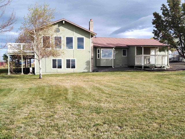 rear view of house featuring a yard and a wooden deck