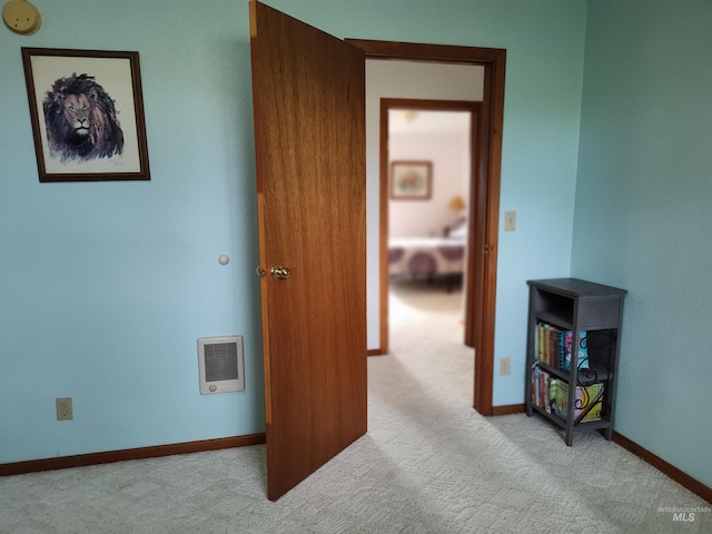 interior space with light colored carpet and heating unit