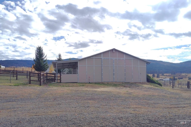 view of outdoor structure with a mountain view and a rural view