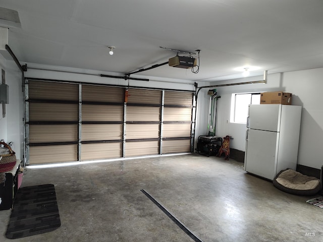 garage featuring white fridge and a garage door opener