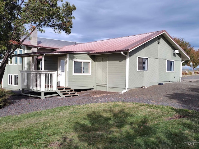 rear view of property featuring a yard and a deck