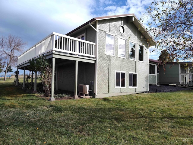 back of property featuring ac unit, a deck, and a lawn