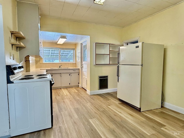 kitchen with electric stove, freestanding refrigerator, light countertops, open shelves, and a sink