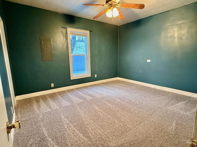 empty room with baseboards, carpet flooring, electric panel, and a ceiling fan