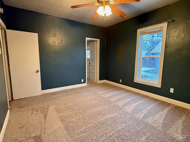 unfurnished room with carpet, baseboards, and a ceiling fan