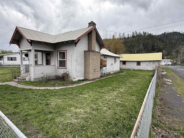 202 S Main St, Kooskia, ID 83539 - view of home's exterior featuring a yard, a chimney, and metal roof