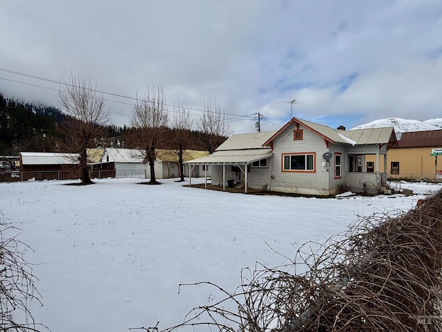 view of snow covered rear of property