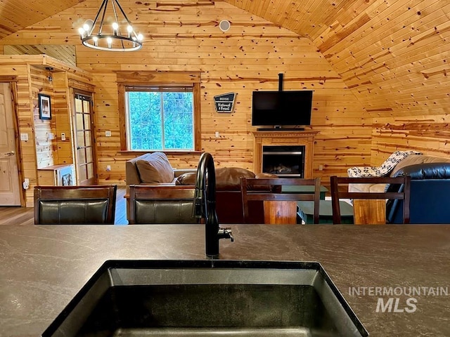 living room featuring wood walls, wooden ceiling, and vaulted ceiling